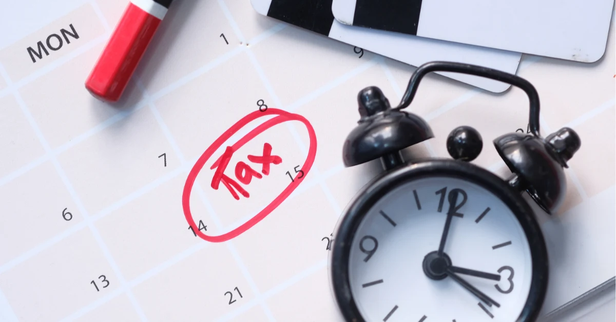 An alarm clock and marked calendar highlight a tax deadline, indicating penalties for late filing.
