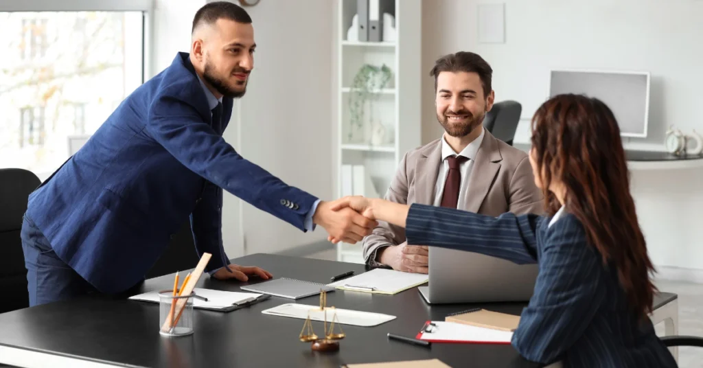 Lawyer shaking hands with a client during a consultation about an Offer in Compromise tax resolution.