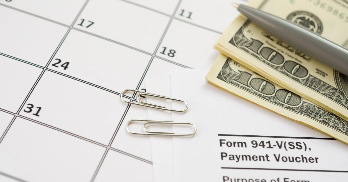 Calendar with cash, Form 941-V, and paper clips representing an ERC refund.